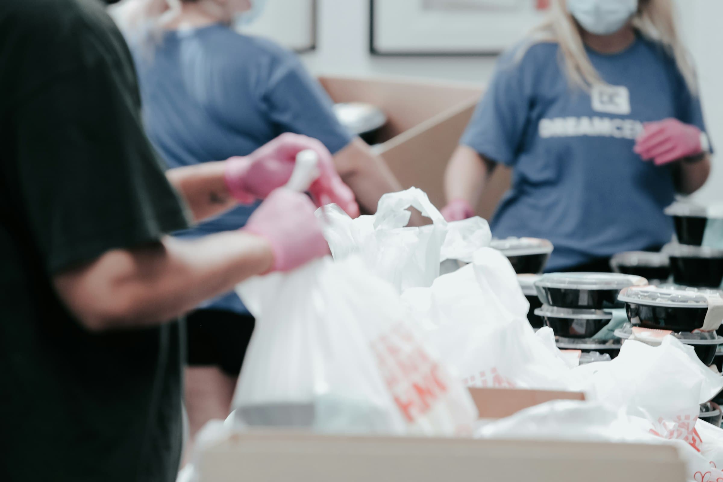 Ehrenamtliche packen Lebensmittel in Tüten